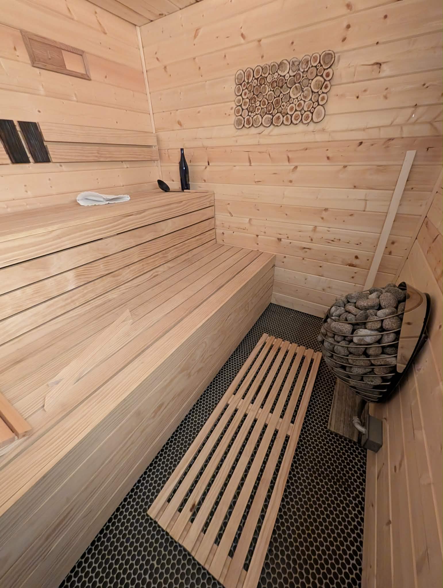 Custom sauna interior with wood benches and stone heater
