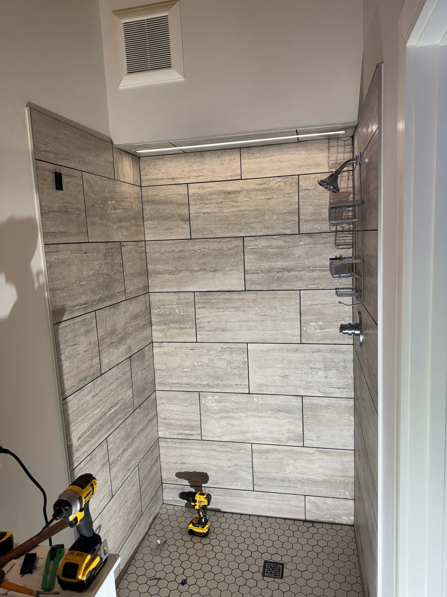 Large-format travertine shower tile in progress